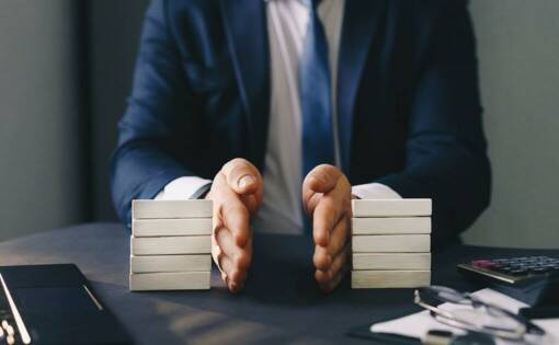 Focus on a persons hands dividing a stack of wooden bricks on a desk